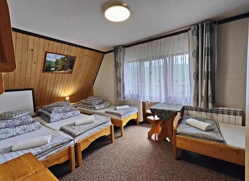 a room with three beds and a window at U Białasów in Małe Ciche