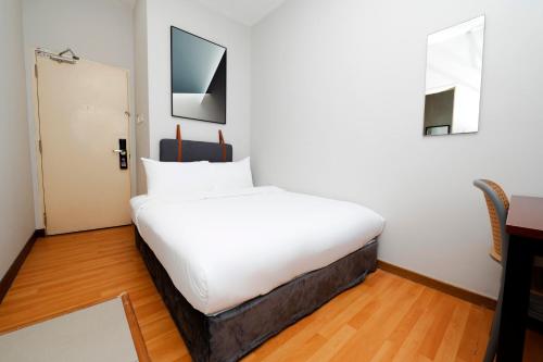 a large white bed in a room with a desk at The Concept Hotel PJCC - Near Sunway Lagoon in Petaling Jaya