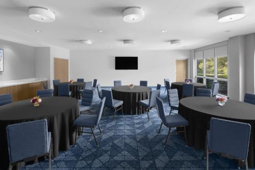 a conference room with tables and chairs and a tv at Courtyard by Marriott Orlando South/Grande Lakes Area in Orlando