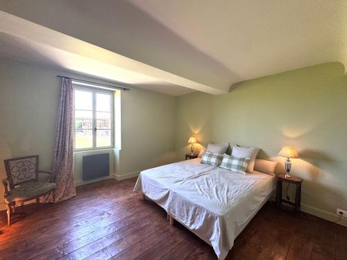 una camera da letto con un letto e una finestra di La Ferme du Château de Grisy, Piscine, 10p a Vendeuvre