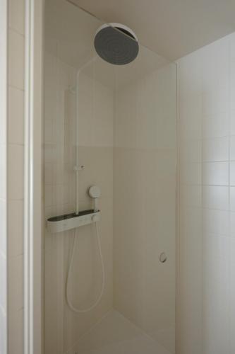 a shower with a shower head in a bathroom at MiHotel - Rue Cuvier in Lyon