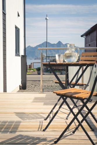 a wooden table with a vase on top of a deck at Spectacular mountain views with fireplace and jacuzzi in Svolvær