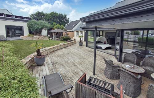 a patio with wicker chairs on a wooden deck at Lovely Home In Landivisiau With Sauna in Landivisiau