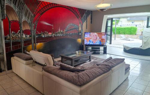 a living room with a couch and a tv at Lovely Home In Landivisiau With Sauna in Landivisiau