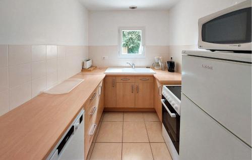 a small kitchen with a sink and a microwave at 3 Bedroom Amazing Home In Jard-Sur-Mer in Jard-sur-Mer