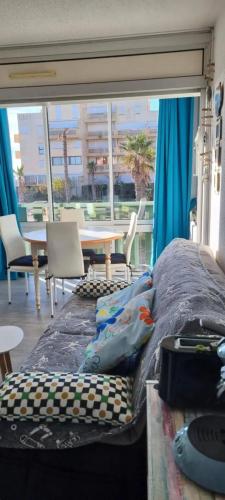 Ce lit se trouve dans un dortoir doté d'une table et de chaises. dans l'établissement Appartement moderne avec vue sur la mer - 29 m² à Le Barcarès, au Barcarès