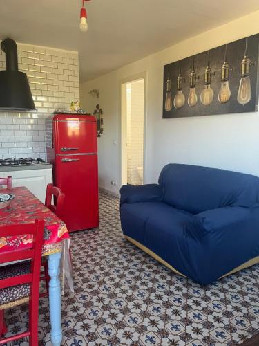 a living room with a blue couch and a red refrigerator at Vista mare 360 in Scopello