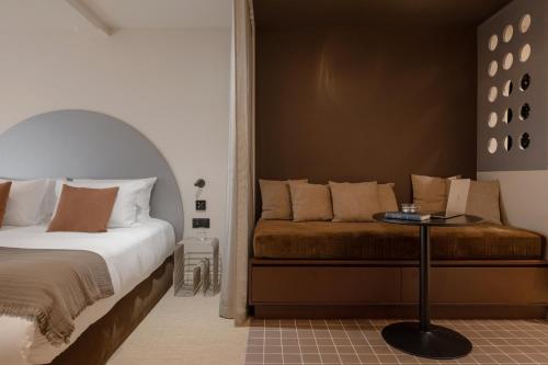 a bedroom with a bed and a table in it at MiHotel - Rue Cuvier in Lyon