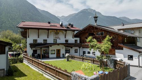 una casa con una valla delante de una montaña en Ferienhaus Ban Brösign, en Umhausen