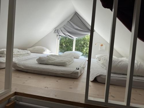 two beds in a room with a window at Log cabin with pool, sauna and boat by Torreby Castle in Munkedal
