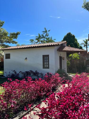 a house with pink flowers in front of it at Pousada Casa da Kátia Lagoa do Cassó in Mata Grande