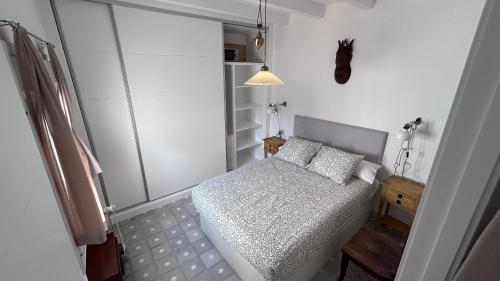 a small bedroom with a bed and a closet at El ático de los mosaicos in Cádiz