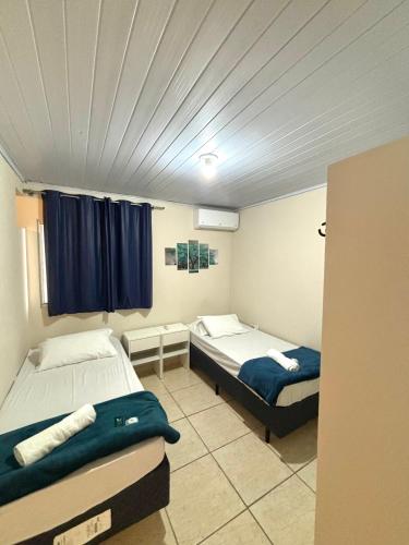 a room with two beds and a ceiling at Hotel São Francisco in São Francisco do Sul