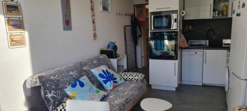 un salon avec un canapé et une cuisine dans l'établissement Appartement moderne avec vue sur la mer - 29 m² à Le Barcarès, au Barcarès