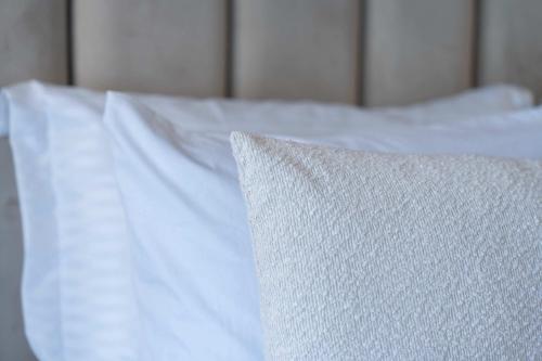 a white bed with white sheets and a pillow at Elegant Comfort Pool Gym & Kids Club in Mohammedia