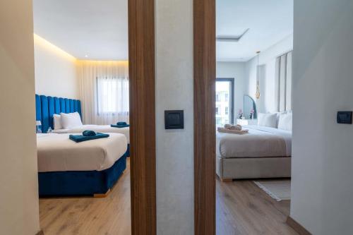 a hotel room with two beds and a mirror at Elegant Comfort Pool Gym & Kids Club in Mohammedia