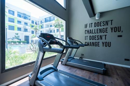 a gym with a treadmill in front of a window at Elegant Comfort Pool Gym & Kids Club in Mohammedia