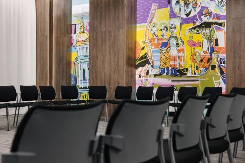 a row of chairs in a room with a painting at Amarant Urban Hotel by CHM in Kyiv