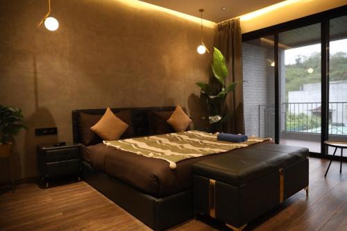 a bedroom with a large bed with a leather couch at Dolce Villa IGATPURI in Igatpuri