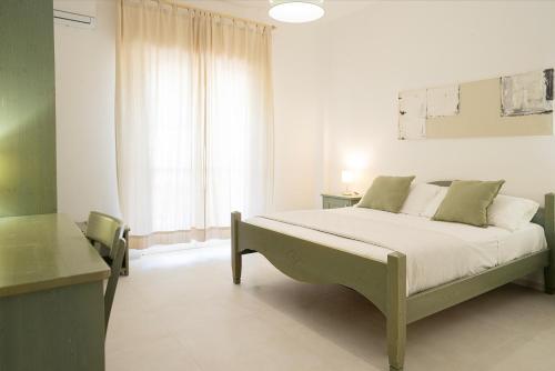 a bedroom with a bed and a desk and a window at Casa Santiago in Agrigento
