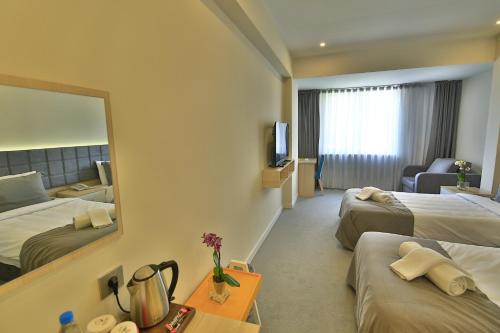 Una habitación de hotel con dos camas y un espejo. en leto city hotel, en Eskisehir