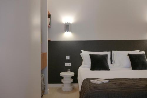 a bedroom with two beds and a light on the wall at MiHotel - Rue Cuvier in Lyon