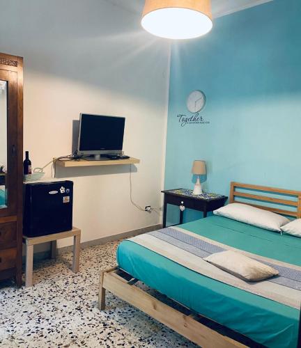 a bedroom with a bed and a tv and a desk at B&B Rifugio Angelina in Vietri sul Mare