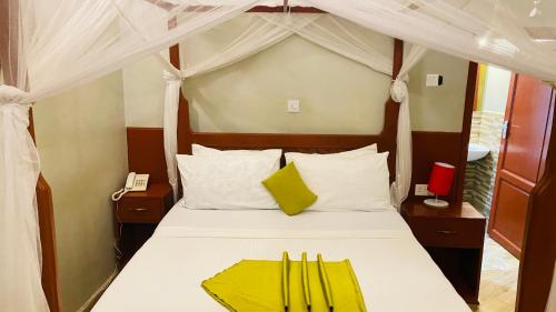 a bedroom with a white bed with a canopy at parachichi house Bed and Breakfast in Arusha