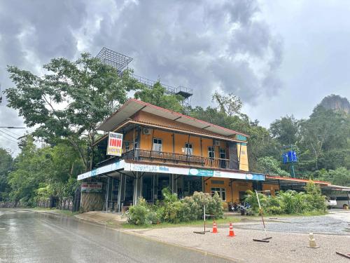 a building on the side of a road next to a street at Khao Sok Inn Hostel in Khao Sok National Park