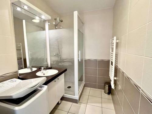 a white bathroom with a sink and a mirror at Appartement moderne 2 pièces avec grand balcon à Étel, proche plage - FR-1-479-166 in Étel