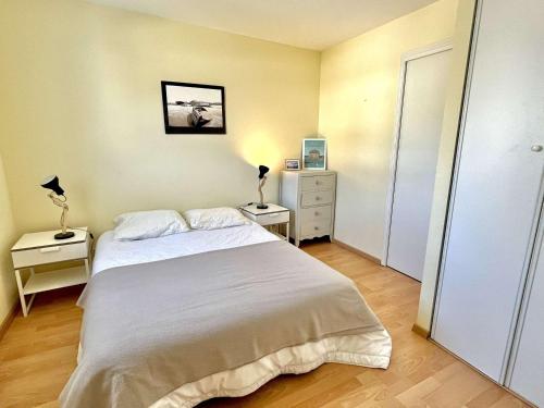 - une chambre avec un grand lit blanc et 2 tables de chevet dans l'établissement Duplex confortable avec climatisation près du port et plages d'Étel - FR-1-479-204, à Étel