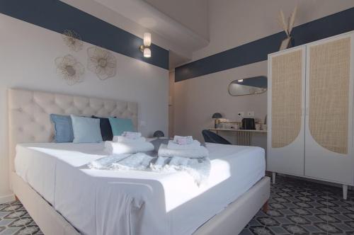 a bedroom with a large white bed with towels on it at Lario Nest - The Suites in Mandello del Lario