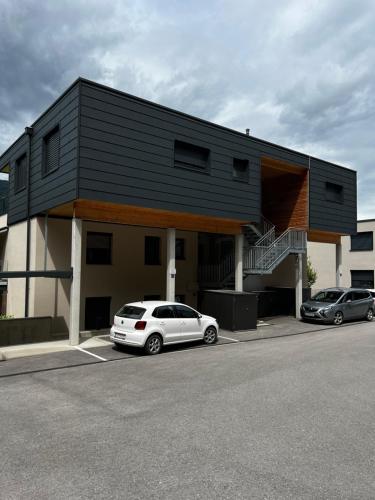 a building with two cars parked in a parking lot at Ossiach Heights - Penthouse mit See- und Bergblick in Altossiach