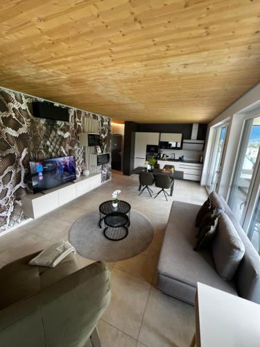 a living room with a couch and a table at Ossiach Heights - Penthouse mit See- und Bergblick in Altossiach