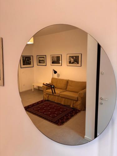un salon avec un canapé et un miroir dans l'établissement Garden Roots - Carozzi Apartments, à Sesto San Giovanni