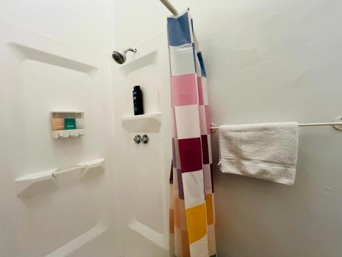 Baño con cortina de ducha colorida y toalla en The Westside New York, en Nueva York