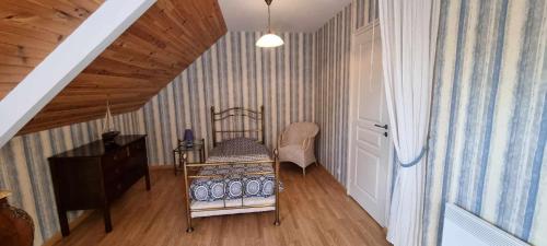 a small room with a bed and a staircase at Gite Le Mascaret in Roz-sur-Couesnon