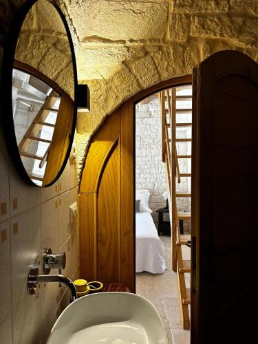 een badkamer met een wastafel en een spiegel bij Nidus Petrae in Alberobello