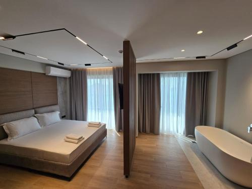 a bedroom with a bed and a couch and some windows at Hotel Selavi in Sarandë