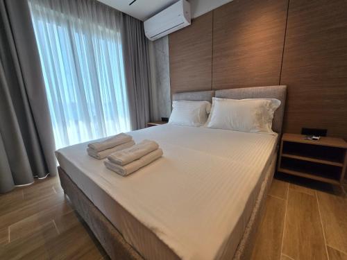 a bedroom with a large bed with two towels on it at Hotel Selavi in Sarandë