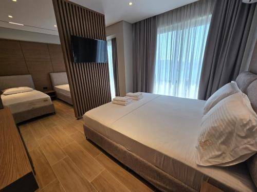 a hotel room with a bed and a television at Hotel Selavi in Sarandë