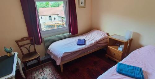 a small bedroom with two beds and a window at La Petite demeure in Le Hohwald