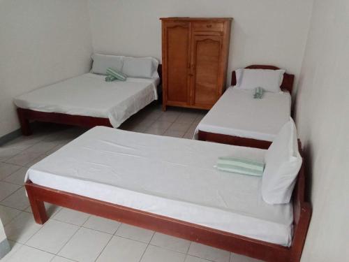 a room with two beds and a cabinet at Pescador View Extension near the Ocean in Moalboal