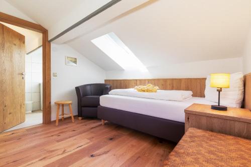 a bedroom with a bed and a chair at Ferienwohnung AUSZEIT mit Wellnessnutzung in Ainring