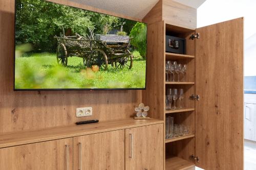 a tv on a wall with a picture of a cart at Ferienwohnung AUSZEIT mit Wellnessnutzung in Ainring