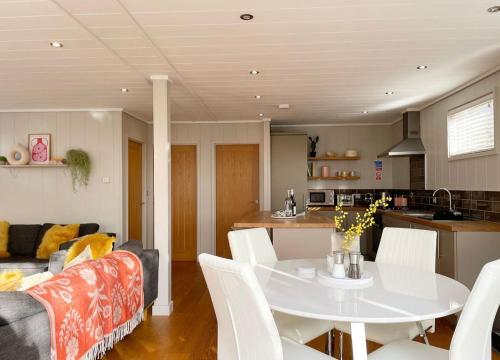 a kitchen and living room with a white table and chairs at The Sleights, Strawberryfield Park - Hot Tub - Free WiFi & Parking - Pets Allowed 2 in Cheddar