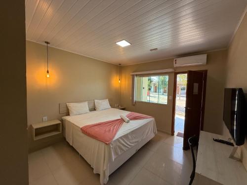 a bedroom with a bed and a tv in it at Pousada Itajuipe II in Vitória da Conquista