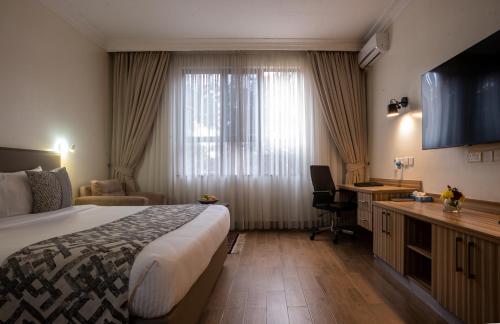 a hotel room with a bed and a desk at Sportsview Hotel Kasarani in Nairobi