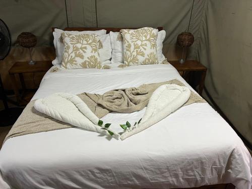 a bed with a blanket and pillows on it at Moz Inn - Coconut View Resort in Lopes