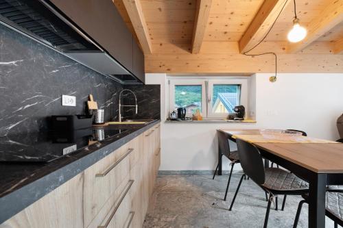 a kitchen with a wooden counter and a table at La Villa di Ludo in San Cassiano